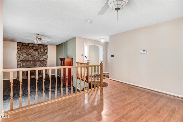 308 Spring Creek Rd, Goldsboro, NC 27534 - empty room featuring a ceiling fan, wood finished floors, a fireplace, a textured ceiling, and a smoke detector