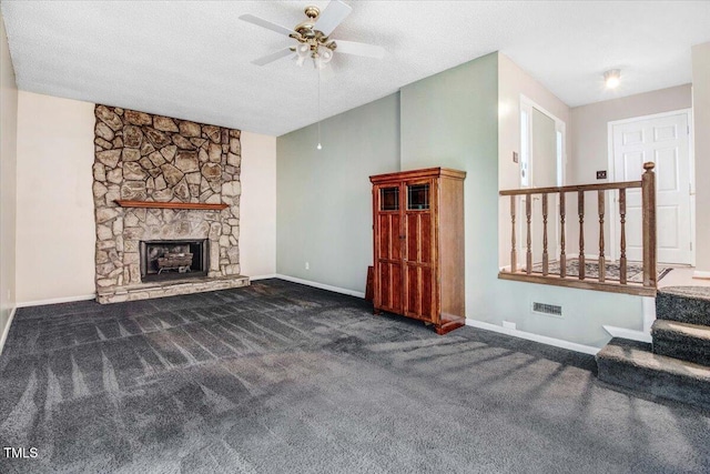 308 Spring Creek Rd, Goldsboro, NC 27534 - unfurnished living room with ceiling fan, carpet, a stone fireplace, a textured ceiling, and stairway