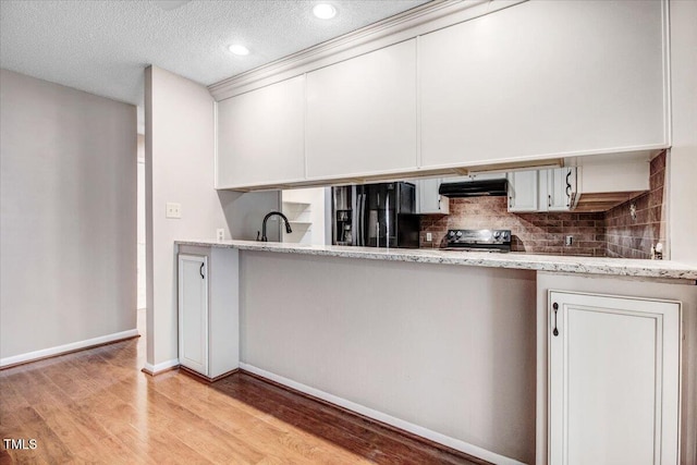 308 Spring Creek Rd, Goldsboro, NC 27534 - kitchen featuring black refrigerator with ice dispenser, under cabinet range hood, range with electric cooktop, light wood-style floors, and white cabinets