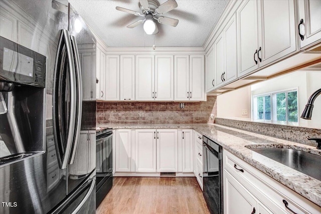 308 Spring Creek Rd, Goldsboro, NC 27534 - kitchen featuring black appliances, a ceiling fan, white cabinetry, light wood-style flooring, and tasteful backsplash