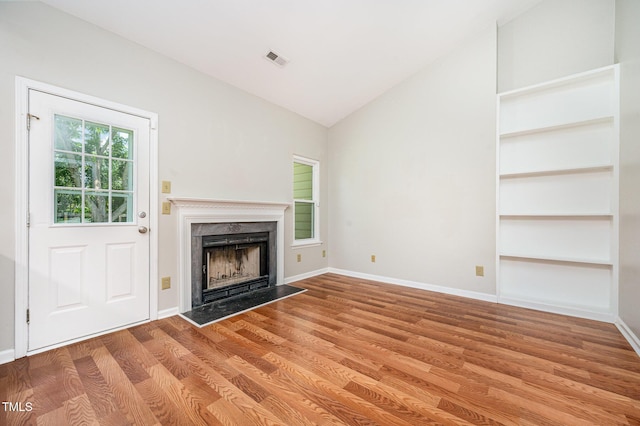 6 Blake Ct, Durham, NC 27712 - unfurnished living room featuring vaulted ceiling, wood finished floors, and a high end fireplace