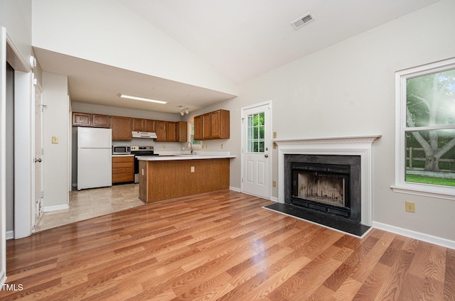 6 Blake Ct, Durham, NC 27712 - kitchen featuring appliances with stainless steel finishes, brown cabinetry, a peninsula, open floor plan, and light countertops