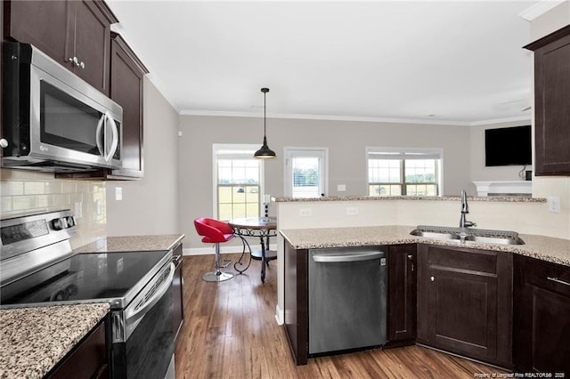 341 Woodington Rd, Hope Mills, NC 28348 - kitchen featuring appliances with stainless steel finishes, dark brown cabinets, dark wood-type flooring, plenty of natural light, and ornamental molding