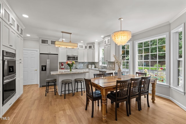 1802 Abby Knoll Dr, Apex, NC 27502 - dining space with healthy amount of natural light, ornamental molding, light wood-style floors, a chandelier, and recessed lighting