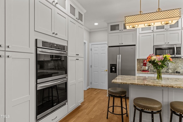 1802 Abby Knoll Dr, Apex, NC 27502 - kitchen featuring stainless steel appliances, a breakfast bar area, decorative backsplash, light wood-type flooring, and recessed lighting
