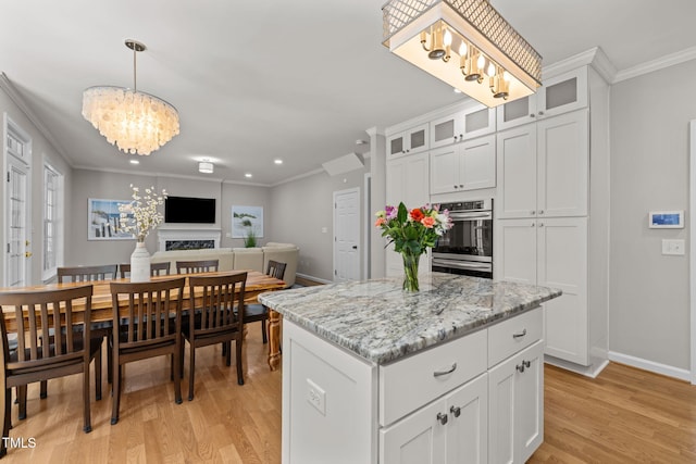1802 Abby Knoll Dr, Apex, NC 27502 - kitchen featuring a chandelier, stainless steel double oven, ornamental molding, light wood-style floors, and white cabinetry