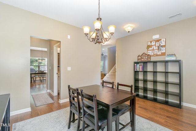 118 Truss Way, Durham, NC 27704 - dining area with a chandelier, wood finished floors, and stairs