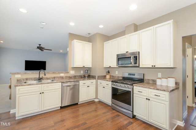 118 Truss Way, Durham, NC 27704 - kitchen featuring appliances with stainless steel finishes, ceiling fan, a peninsula, dark wood-type flooring, and open floor plan