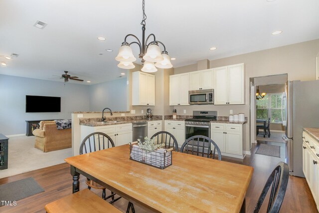 118 Truss Way, Durham, NC 27704 - dining area with a chandelier, wood finished floors, a ceiling fan, and recessed lighting