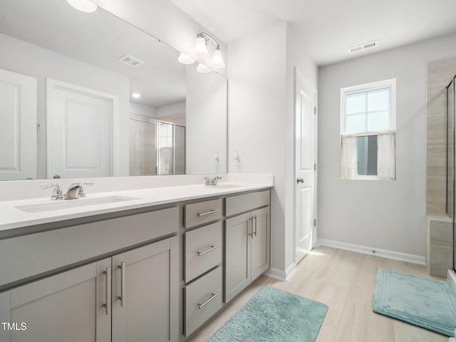 1650 Singing Bird Trl, Wake Forest, NC 27587 - bathroom with a stall shower, double vanity, and wood finished floors