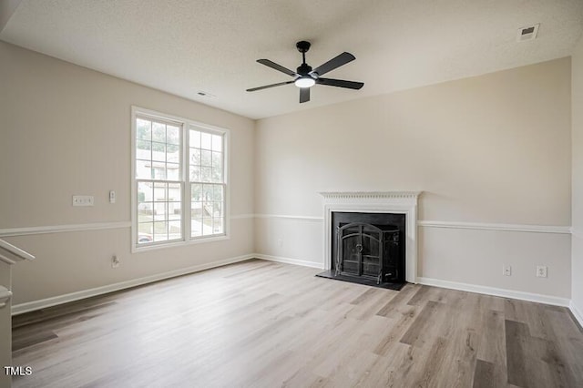 413 Hanska Way, Raleigh, NC 27610 - unfurnished living room featuring wood finished floors, a ceiling fan, and a fireplace