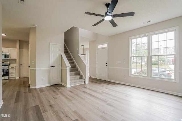 413 Hanska Way, Raleigh, NC 27610 - unfurnished living room featuring stairway, light wood finished floors, and a ceiling fan