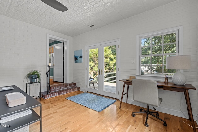 2706 Stuart Dr, Durham, NC 27707 - office space featuring an ornate ceiling, wood finished floors, brick wall, french doors, and a ceiling fan