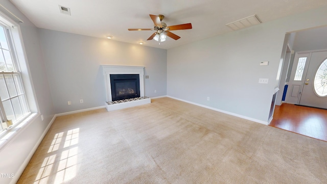 14 Gloucester Ct, Cameron, NC 28326 - unfurnished living room featuring carpet floors, a ceiling fan, and a glass covered fireplace