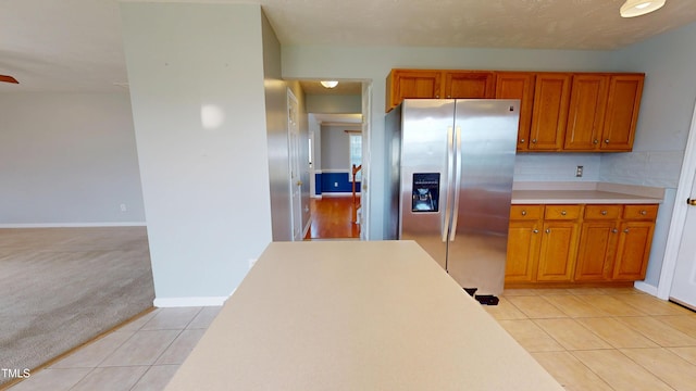 14 Gloucester Ct, Cameron, NC 28326 - kitchen with stainless steel fridge, brown cabinets, light tile patterned floors, and light countertops