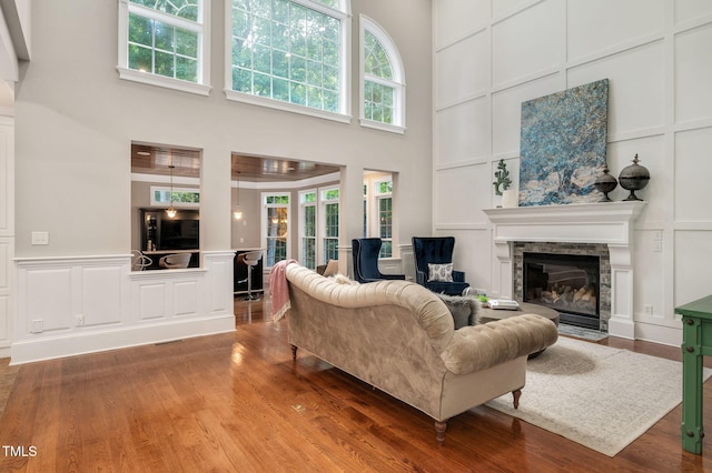 12452 Richmond Run Dr, Raleigh, NC 27614 - living area with a decorative wall, a fireplace with flush hearth, a towering ceiling, plenty of natural light, and wood finished floors