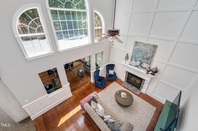 12452 Richmond Run Dr, Raleigh, NC 27614 - living room featuring a decorative wall, a fireplace with flush hearth, a ceiling fan, dark wood finished floors, and a high ceiling