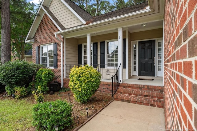 85 Shining Water Ln, Spring Lake, NC 28390 - property entrance featuring brick siding, a porch, and a shingled roof