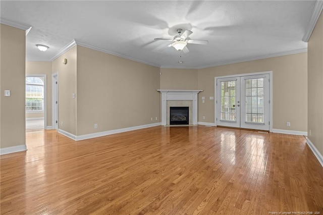 85 Shining Water Ln, Spring Lake, NC 28390 - unfurnished living room with a ceiling fan, light wood-style floors, a fireplace with flush hearth, crown molding, and french doors