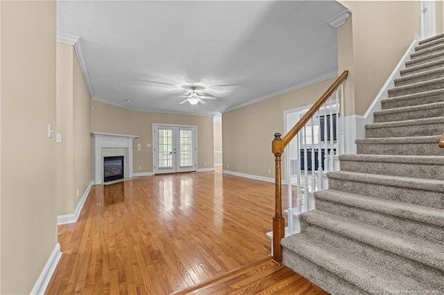 85 Shining Water Ln, Spring Lake, NC 28390 - unfurnished living room featuring ceiling fan, stairway, wood finished floors, crown molding, and a glass covered fireplace