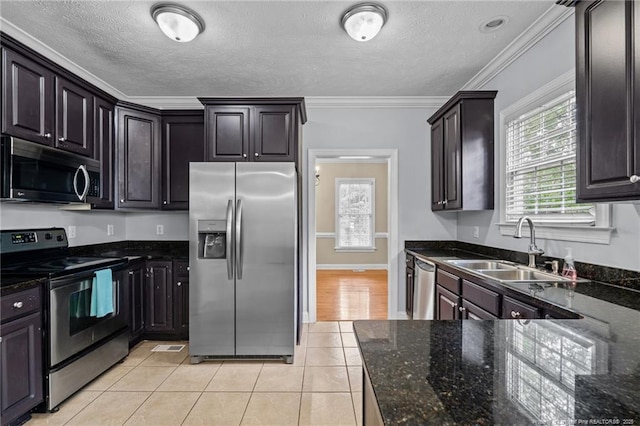 85 Shining Water Ln, Spring Lake, NC 28390 - kitchen with stainless steel appliances, ornamental molding, light tile patterned floors, dark stone countertops, and a textured ceiling