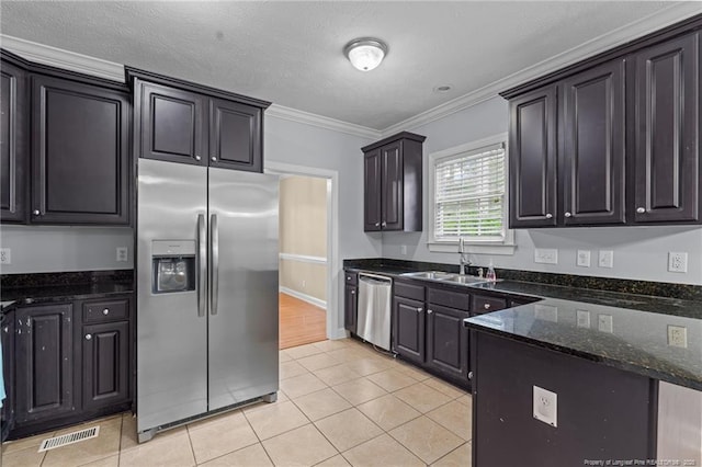 85 Shining Water Ln, Spring Lake, NC 28390 - kitchen with appliances with stainless steel finishes, crown molding, light tile patterned flooring, dark stone counters, and a peninsula