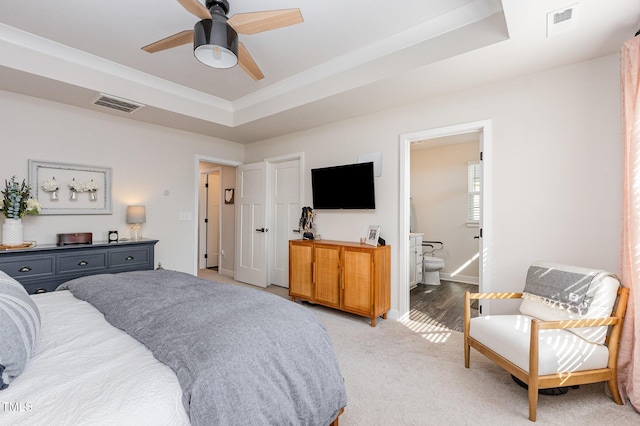 235 Misty Pike Dr, Raleigh, NC 27603 - bedroom featuring a tray ceiling, light colored carpet, ensuite bath, and a ceiling fan
