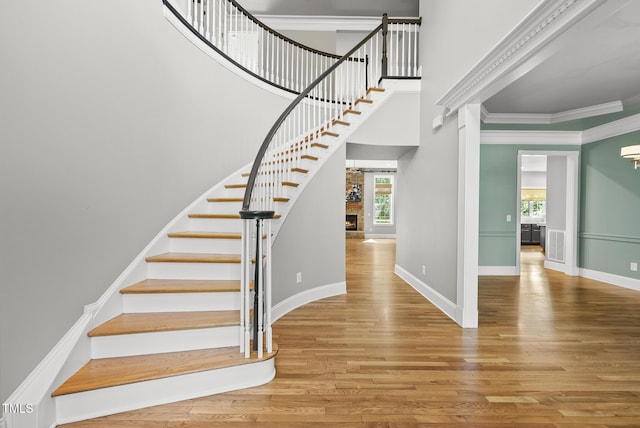 7112 Hasentree Way, Wake Forest, NC 27587 - staircase with plenty of natural light, wood finished floors, crown molding, a fireplace, and a high ceiling