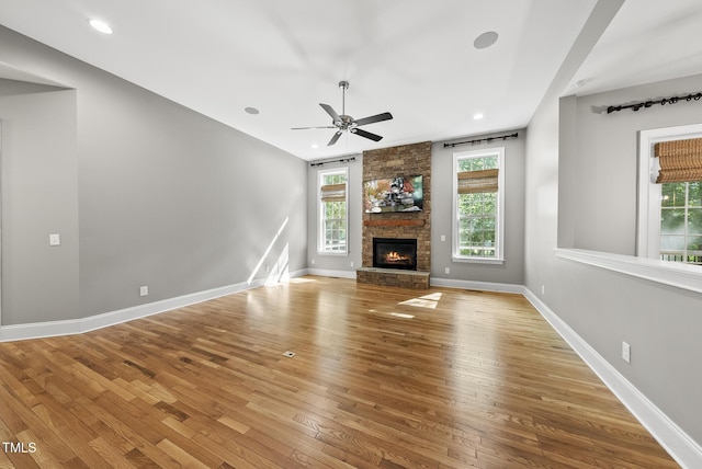 7112 Hasentree Way, Wake Forest, NC 27587 - unfurnished living room featuring wood-type flooring, a ceiling fan, a large fireplace, and recessed lighting