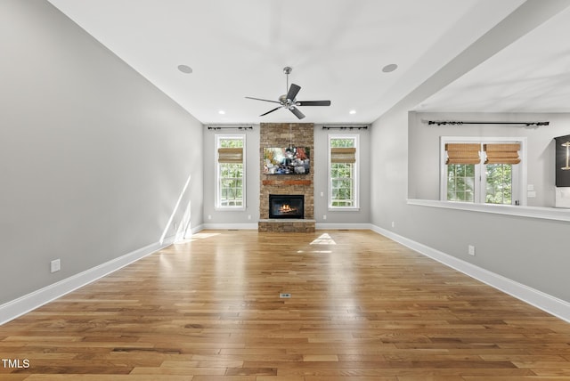 7112 Hasentree Way, Wake Forest, NC 27587 - unfurnished living room with ceiling fan, hardwood / wood-style flooring, a stone fireplace, and recessed lighting