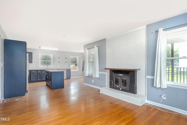 3542 Anderson Valley Rd, Mcleansville, NC 27301 - unfurnished living room with wood finished floors and a brick fireplace