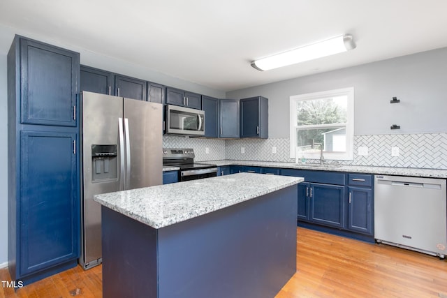 3542 Anderson Valley Rd, Mcleansville, NC 27301 - kitchen featuring stainless steel appliances, blue cabinetry, backsplash, light stone counters, and a center island
