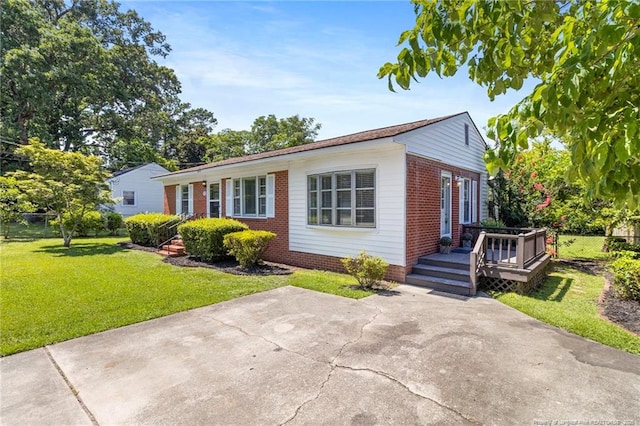 3810 David St, Fayetteville, NC 28304 - view of front of home featuring brick siding, a front lawn, a deck, and a patio