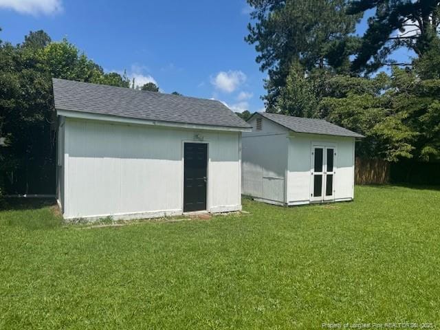 5027 Chesapeake Rd, Fayetteville, NC 28311 - rear view of house featuring a storage unit, a lawn, and roof with shingles