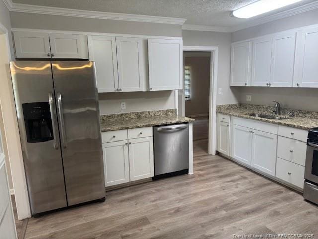 5027 Chesapeake Rd, Fayetteville, NC 28311 - kitchen featuring stainless steel appliances, crown molding, light wood finished floors, white cabinetry, and stone counters