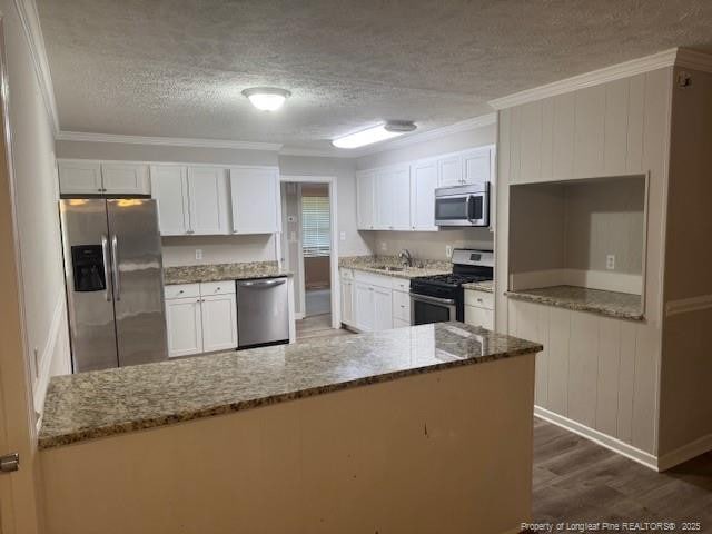5027 Chesapeake Rd, Fayetteville, NC 28311 - kitchen with stainless steel appliances, a textured ceiling, white cabinetry, dark wood finished floors, and stone counters