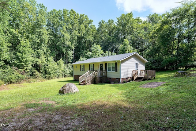 8905 Dukes Lake Rd, Zebulon, NC 27597 - view of front of house with crawl space, a front yard, a view of trees, and a deck