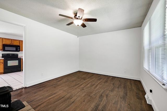 8905 Dukes Lake Rd, Zebulon, NC 27597 - empty room with ceiling fan, wood finished floors, plenty of natural light, and a textured ceiling