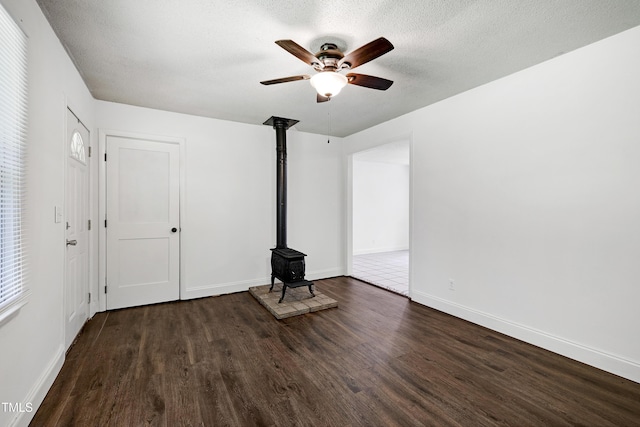 8905 Dukes Lake Rd, Zebulon, NC 27597 - unfurnished living room with a wood stove, a ceiling fan, wood finished floors, and a textured ceiling
