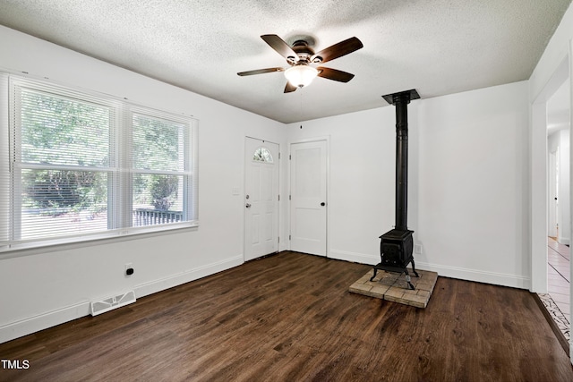 8905 Dukes Lake Rd, Zebulon, NC 27597 - entrance foyer with a wood stove, wood finished floors, a textured ceiling, and a ceiling fan