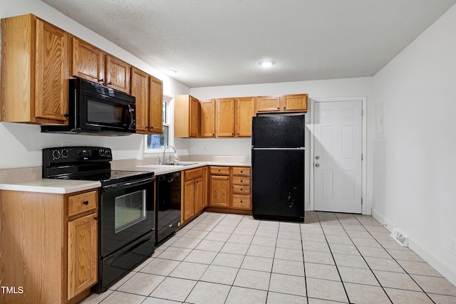 8905 Dukes Lake Rd, Zebulon, NC 27597 - kitchen with black appliances, light countertops, light tile patterned flooring, brown cabinets, and recessed lighting