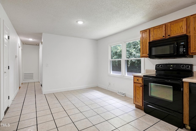 8905 Dukes Lake Rd, Zebulon, NC 27597 - kitchen featuring black appliances, light countertops, brown cabinets, a textured ceiling, and light tile patterned floors
