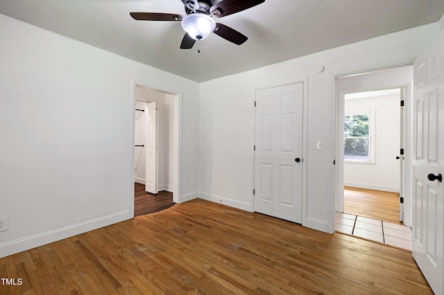 8905 Dukes Lake Rd, Zebulon, NC 27597 - unfurnished bedroom featuring wood finished floors, ensuite bathroom, and a ceiling fan