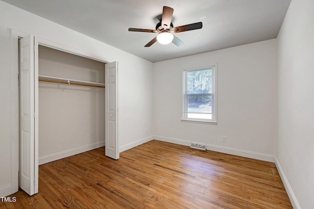 8905 Dukes Lake Rd, Zebulon, NC 27597 - unfurnished bedroom with wood finished floors, a closet, and ceiling fan