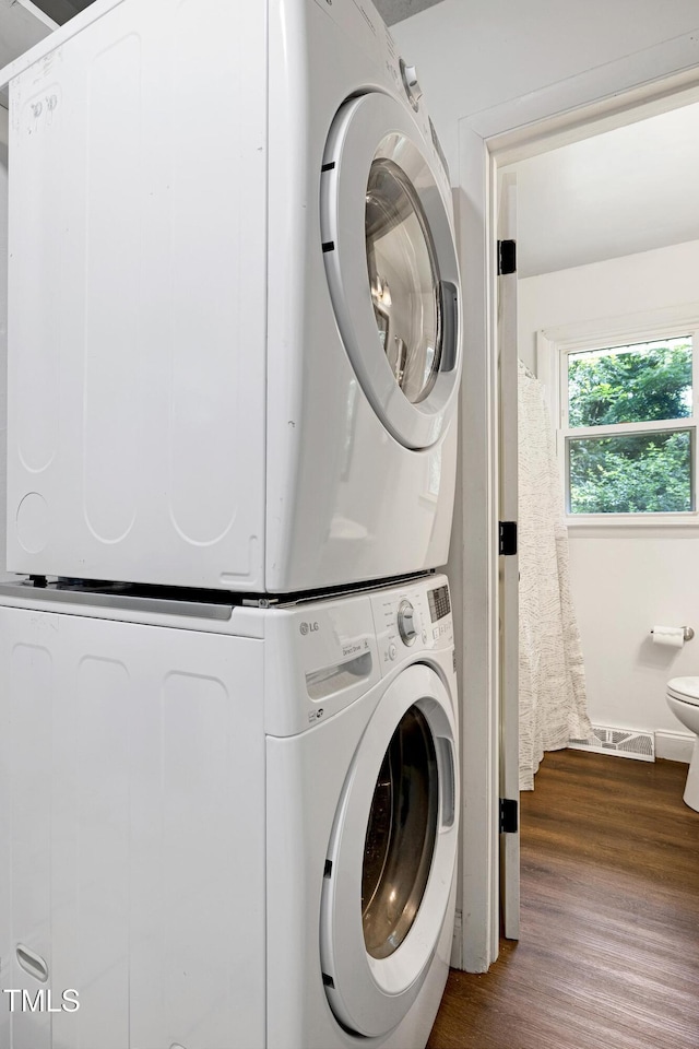 8905 Dukes Lake Rd, Zebulon, NC 27597 - laundry room with stacked washing machine and dryer and dark wood-style floors