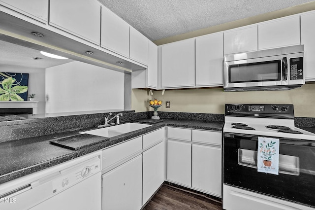 116 Saint Andrews Ln, Chapel Hill, NC 27517 - kitchen with electric range, stainless steel microwave, white dishwasher, white cabinets, and a textured ceiling