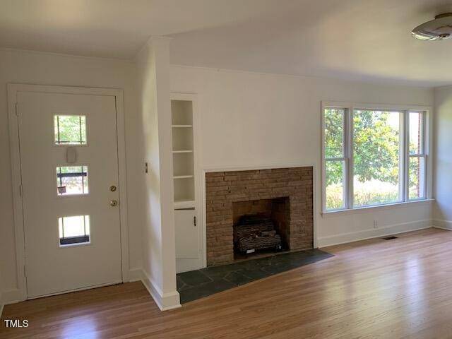 1003 Summerville Mamers Rd, Lillington, NC 27546 - unfurnished living room featuring wood finished floors, a fireplace with flush hearth, and built in features