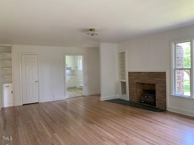 1003 Summerville Mamers Rd, Lillington, NC 27546 - unfurnished living room featuring built in features, light wood finished floors, and healthy amount of natural light