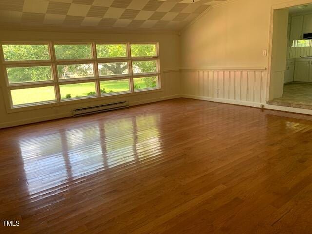 1003 Summerville Mamers Rd, Lillington, NC 27546 - unfurnished room featuring a baseboard radiator, wood finished floors, vaulted ceiling, and a wainscoted wall