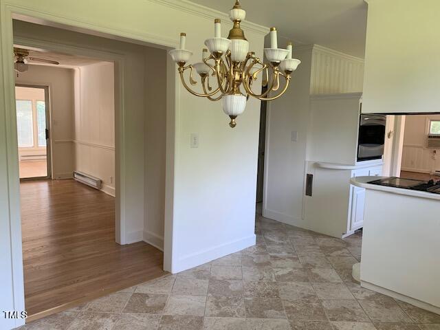 1003 Summerville Mamers Rd, Lillington, NC 27546 - unfurnished dining area featuring a chandelier, baseboard heating, and light stone finish flooring